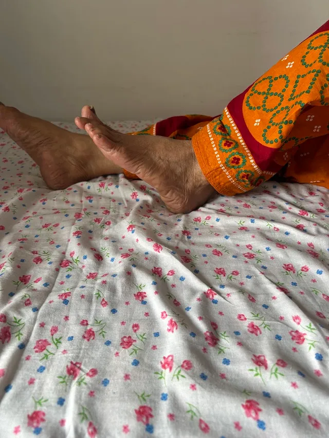 A home physiotherapy session in progress, with the patient seated on a bed for treatment